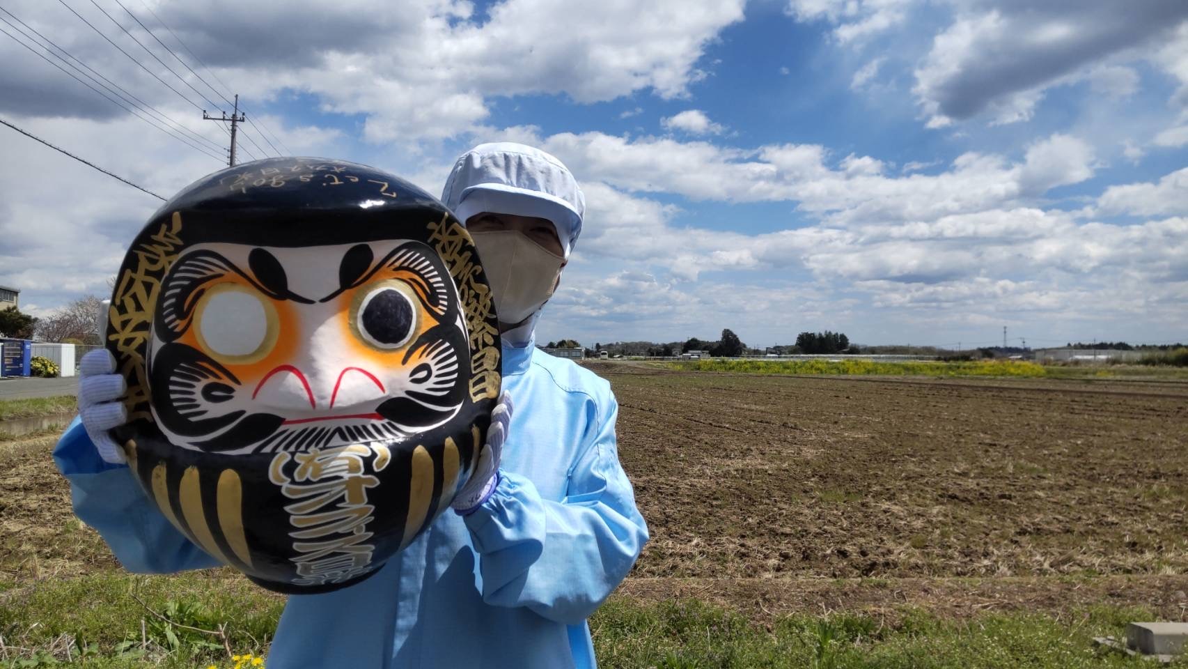 立春ダルマ書きのダルマと従業員さんの写真