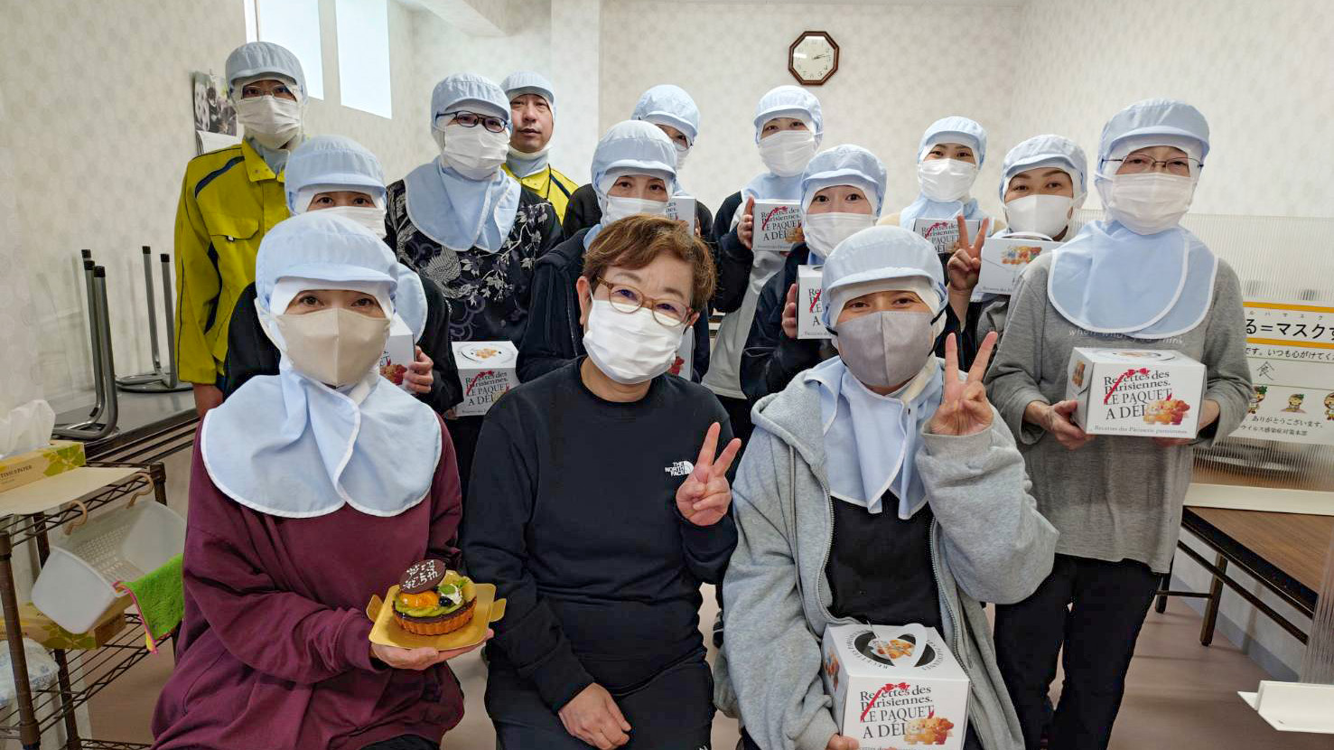 芦沼移転5周年を記念したケーキを持って社内で撮影した集合写真